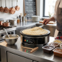 Crêpière électrique professionnelle installée sur un plan de travail en inox dans une cuisine de restaurant. Une grande crêpe do