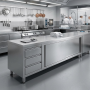 Meuble inox installé au centre d’une cuisine professionnelle moderne et lumineuse. Il sert de plan de préparation, avec quelques