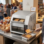 Grille-pain convoyeur professionnel en inox installé sur un buffet de petit-déjeuner dans un établissement hôtelier. Deux tranch