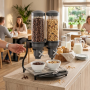 Distributeur de céréales double installé sur un buffet de petit-déjeuner dans un espace de restauration lumineux. Les deux réser