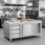 Table de travail en acier inoxydable installée dans une cuisine professionnelle. Un chef prépare des assiettes sur le plan de tr