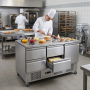 Table réfrigérée professionnelle en inox à quatre tiroirs et une porte, utilisée comme plan de préparation pâtissière dans une c